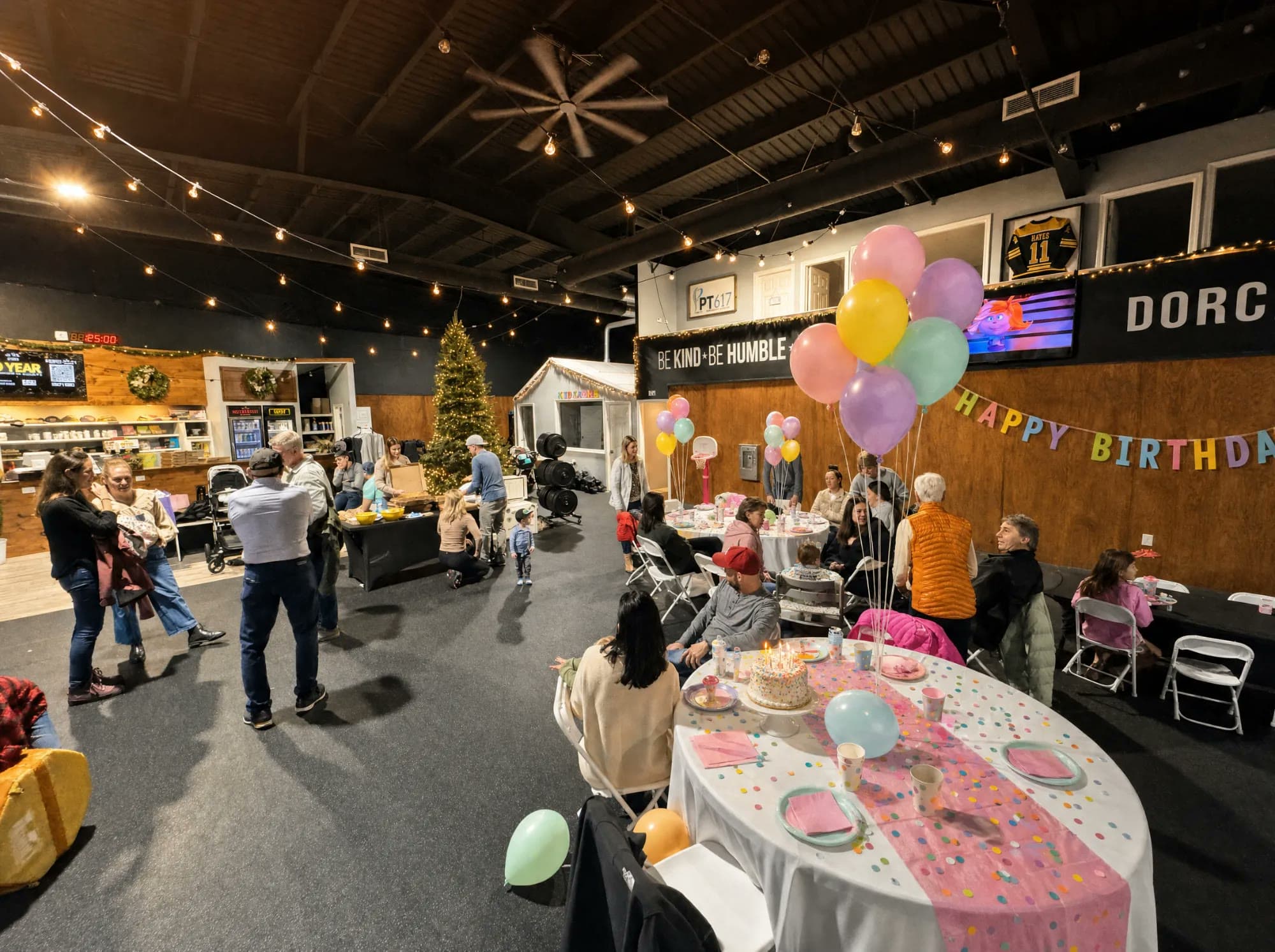 A birthday party table set up with a cake, balloons, and decorations at CrossFit 617 Dorchester